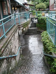 an alley way with steps leading up and down to the building where it is located