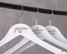 three white wooden hangers with names on them