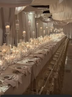 a long table is set up with candles and place settings for an elegant wedding reception