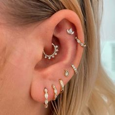 a woman's ear with three different types of piercings