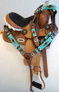 a saddle with turquoise and white accents on it's back end, sitting on top of a table