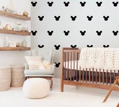 a baby's room with mickey mouse decals on the wall and a crib