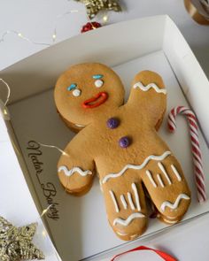 a gingerbread man in a box with candy canes