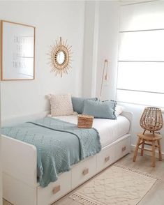 a white bed with blue sheets and pillows