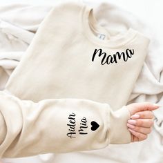 Personalised Mama Sweatshirt and heart with children's names on the sleeve, Mama top, Mothers Day Gift, Mom sweater. Personalised gift. This listing is for a high quality bespoke Mum sweatshirt that is a hand made item, made to order. Our Mama Sweatshirt is handmade with the finest machinery ensuring the ultimate quality for you. Using only premium  sweatshirts, your handmade Shirt will be SUPER soft and SUPER comfy Material: Luxuriously soft blend of 80% Cotton and 20% Polyester. Handmade Quality: Crafted with the finest machinery for unmatched quality. Customisation: Personalise with names! Add details in the 'personalisation section' at checkout. (Note: Exact spelling as provided will be used.) Design Options: Choose between printed or blank styles. How to Order ❤️ Select the colour and Blessed Grandma, Svg Grandma, Grandma Sweatshirt, Mom Outfit, Handmade Shirts, Mom Sweater, New Grandma, Valentine Svg, Personalized Grandma