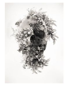 a black and white photo of a human skull surrounded by flowers on a white background