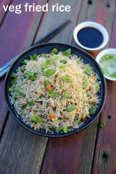 a bowl filled with rice and veggies next to dipping sauce