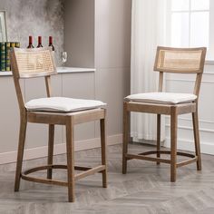 two wooden chairs sitting next to each other in a room