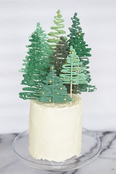 there is a cake decorated with trees on the top and frosting in the bottom