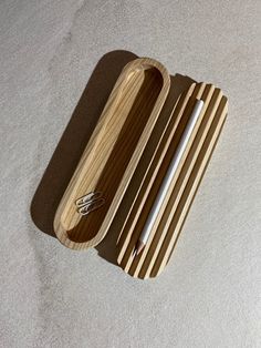 a wooden tray with two utensils in it on a white carpeted floor