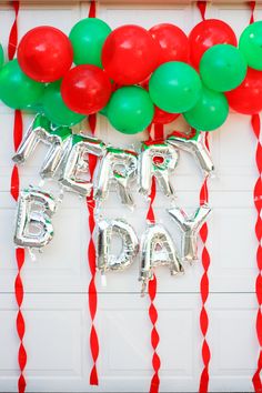 balloons and streamers are hanging on the wall for a happy birthday party at home