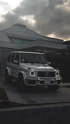 a mercedes g - class parked in front of a house