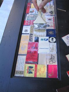 a person using a paint brush to decorate a piece of artwork on a table top