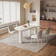 a white table and chairs in a room with wooden floors, windows, and blinds