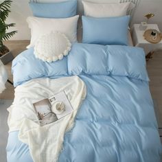 a bed with blue sheets and white pillows