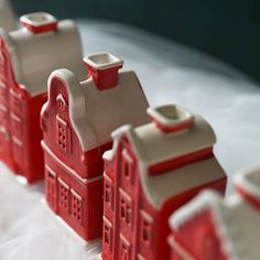 small red and white houses sitting on top of a table next to eachother