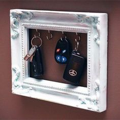 a white frame with two keys hanging on it