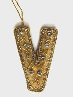 a gold and white beaded letter v ornament