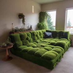 a green couch covered in grass next to a window