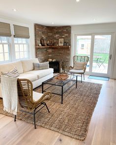 a living room filled with furniture and a fire place next to a brick wall in the corner