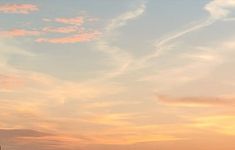 two people are flying kites on the beach at sunset