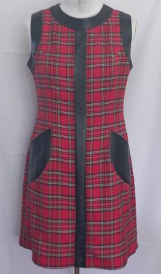 a red and black plaid dress on a mannequin headdress with leather accents