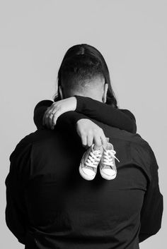 two people hugging each other in black and white