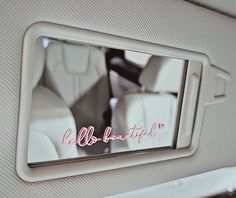 the interior of a car with an advertisement on the front window and pink lettering that reads, all beautiful