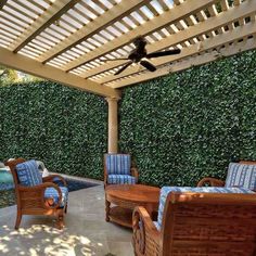 an outdoor living area with wicker furniture and a pool in the backgroud