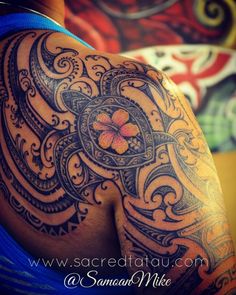 the back of a woman's shoulder with an intricate tattoo design on her arm