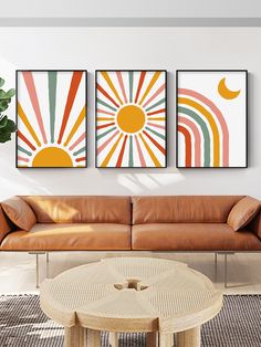 three paintings on the wall above a couch in a living room with a coffee table