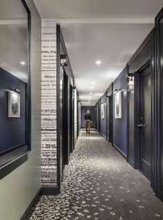 a long hallway with black walls and white carpet