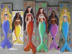 four mermaids painted on wooden planks in different colors