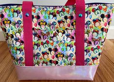 a multicolored mickey mouse tote bag with pink handles