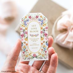 a person holding up a business card that says let love bloom