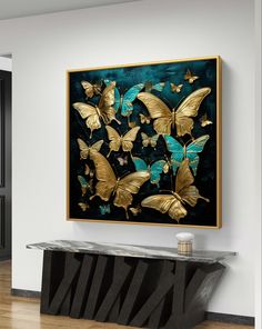 a painting with gold butterflies on it in a white walled room next to a black table