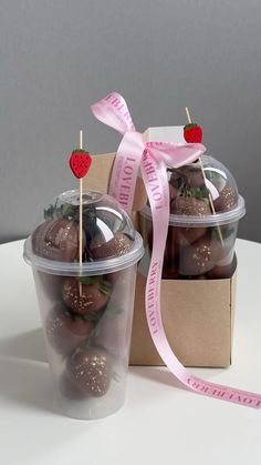 two plastic cups filled with chocolate covered strawberries