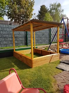 a wooden play area with swings and slides in the back yard at a children's park