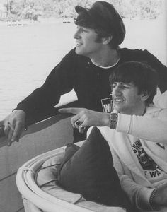 two young men sitting next to each other on a boat