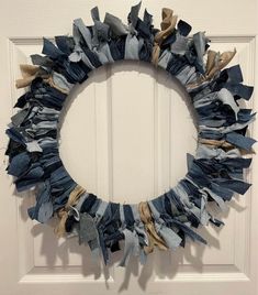 a wreath made out of old jeans hanging on a door