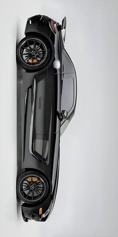 an overhead view of a black sports car with its hood up and wheels down, on a white background