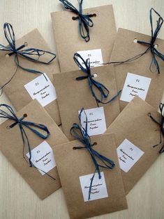 six brown envelopes tied with blue string and twine on top of each other