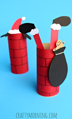 an image of some paper crafts made to look like santa claus and penguin in the chimney