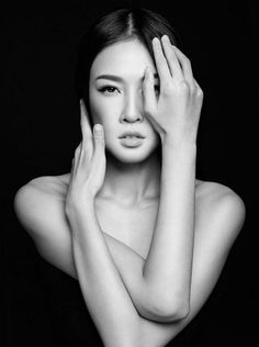 black and white photograph of a woman with her hands on her face, posing for the camera