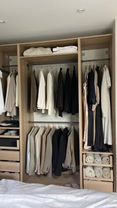 an organized closet with clothes hanging on shelves