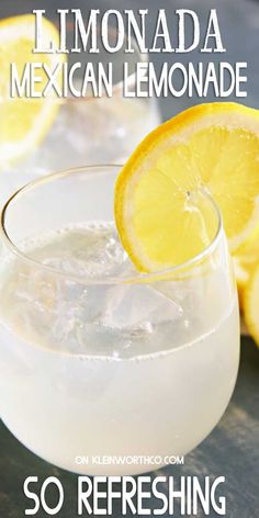 a glass filled with lemonade sitting on top of a table