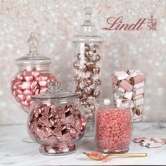 pink and silver candies are in glass containers