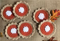 four crocheted coasters with leaves on them