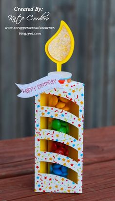 an open birthday card box with candies in it and a candle sticking out of the top