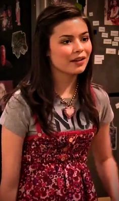 a young woman wearing an apron in front of a refrigerator